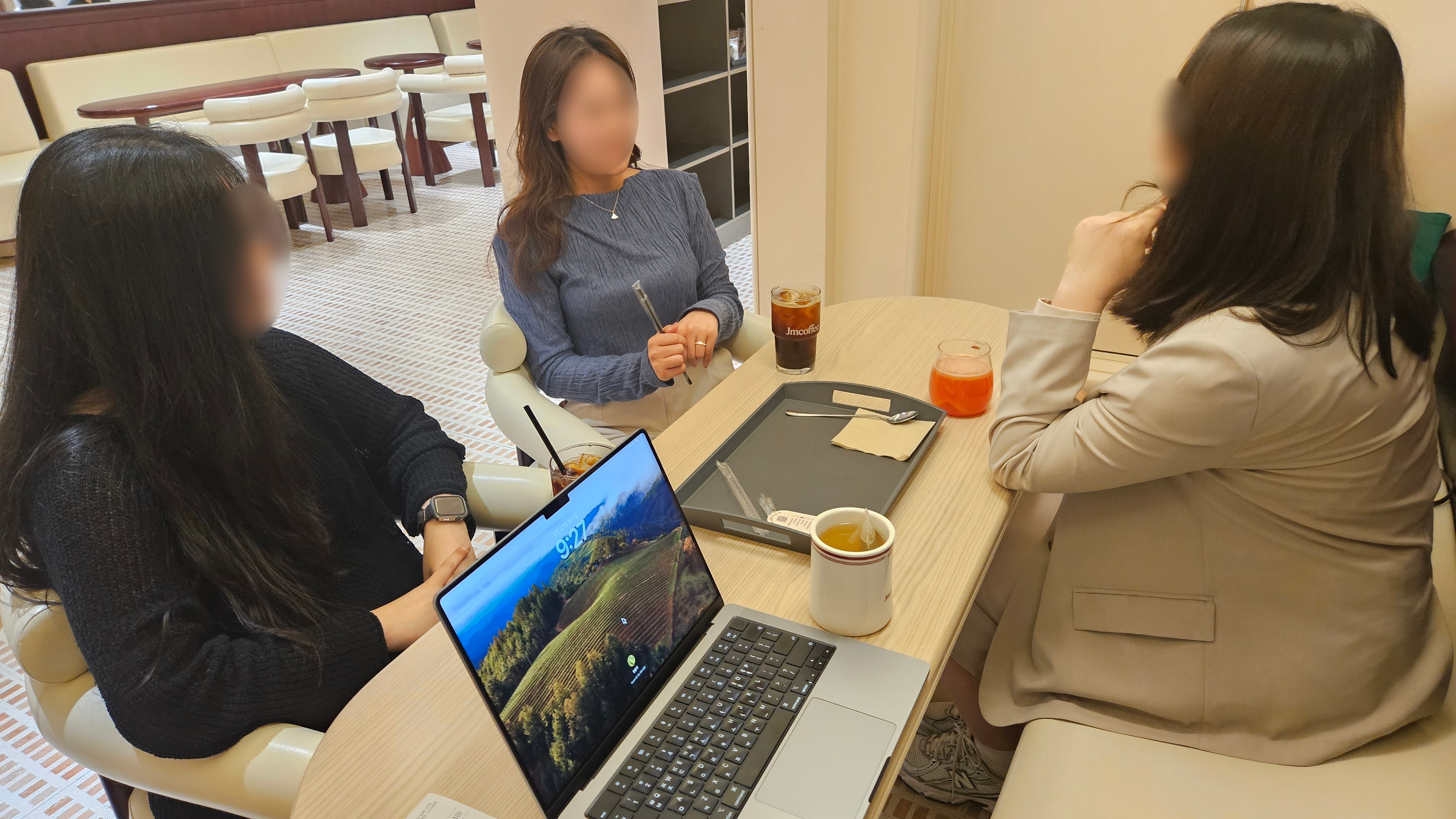 창업가들이 카페에서 노트북을 펼치고 대화하는 모습